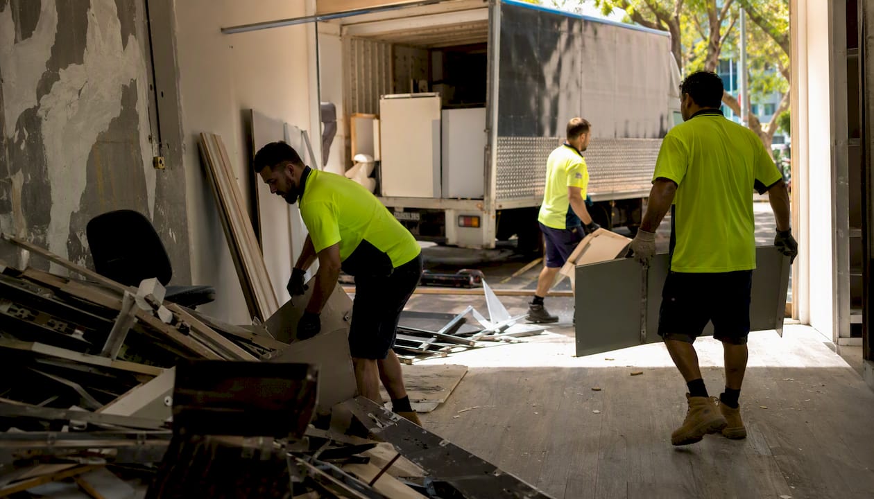 Workers loading commercial demolition debris into truck