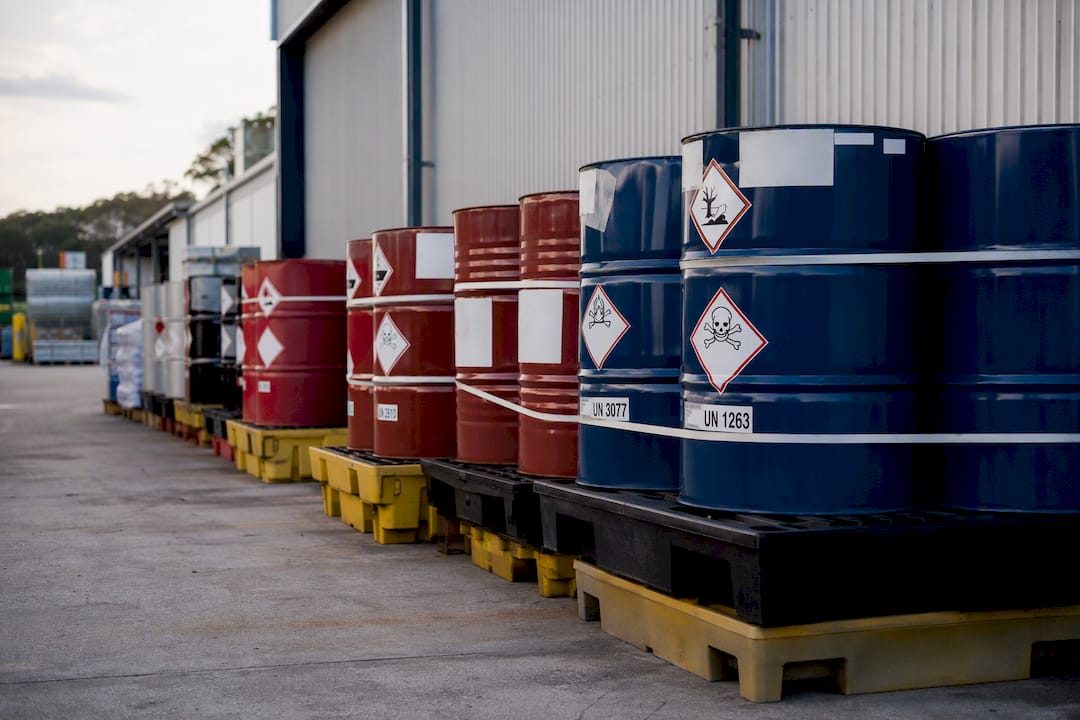 Labelled hazardous waste containers in commercial storage