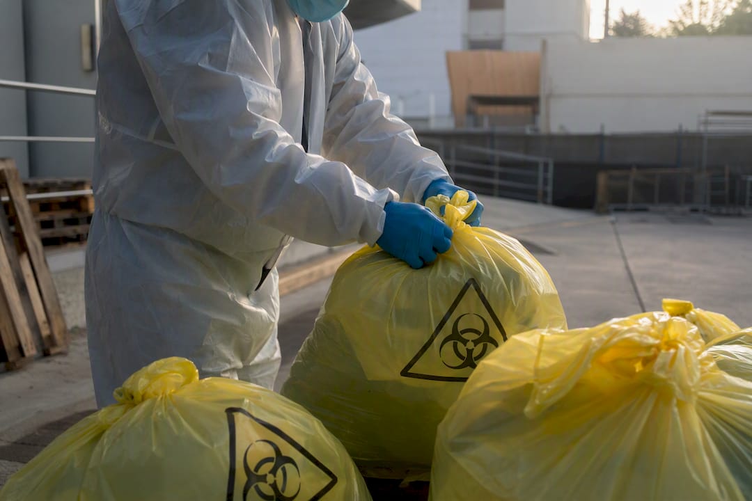 Hands inspecting hazardous waste bags