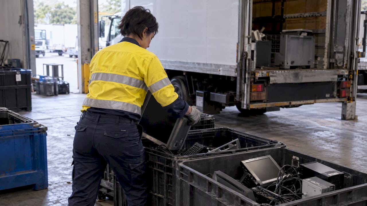 Worker separating office electronic waste for disposal