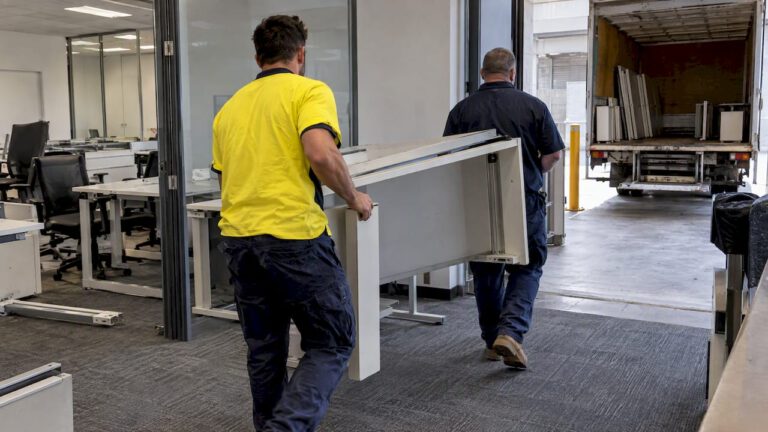 Crew moving dismantled office furniture for removal