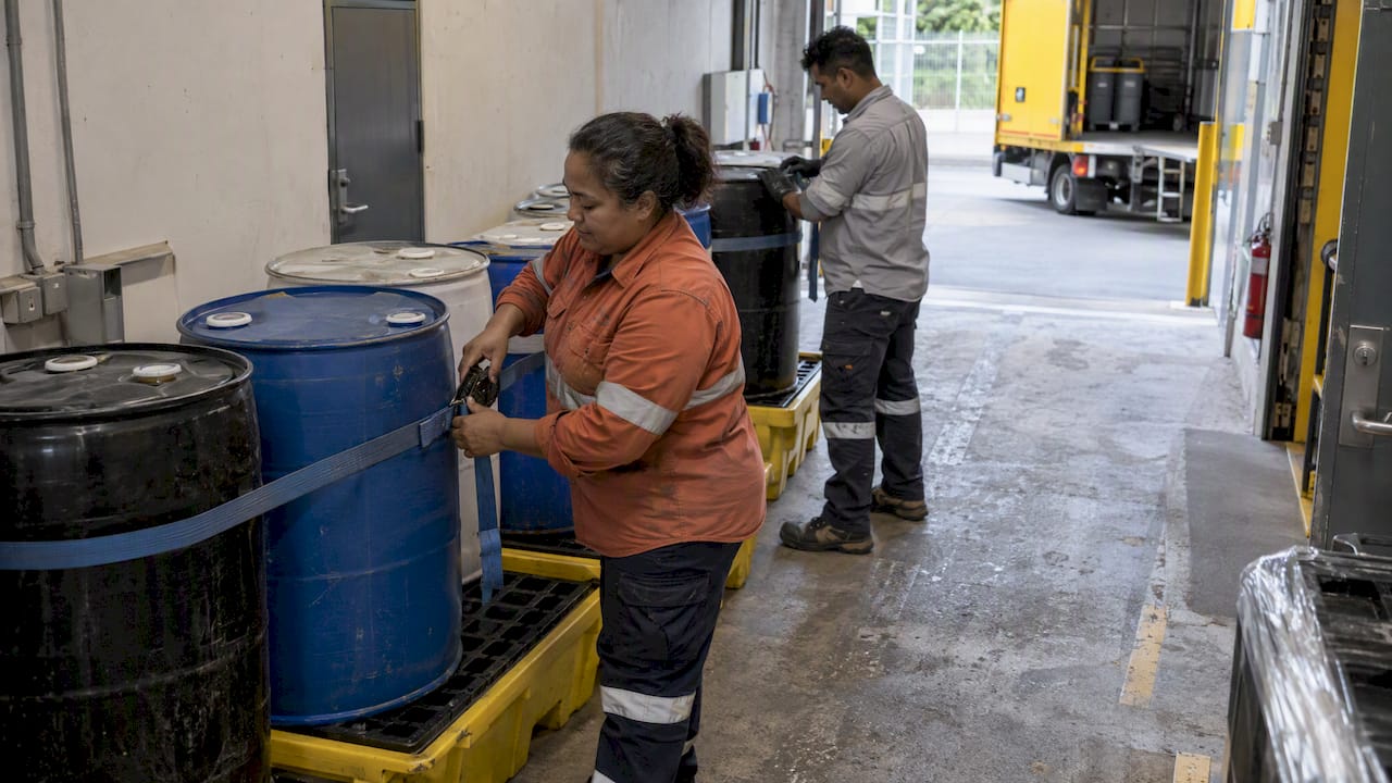 Commercial crew securing hazardous waste for collection